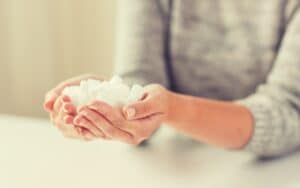 close up of white lump sugar in woman hands